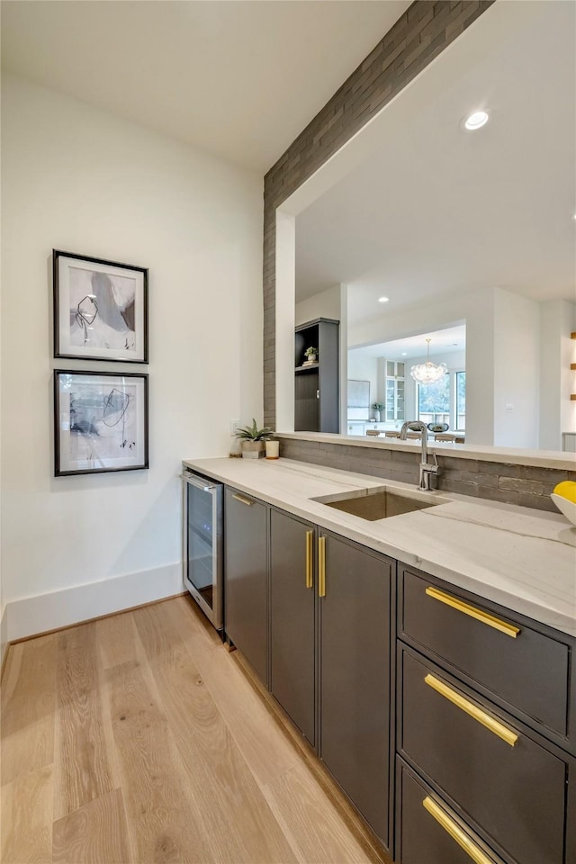1322 Candlelight Ln, Houston, TX 77018 - kitchen featuring a sink, beverage cooler, a chandelier, light wood-style flooring, and baseboards
