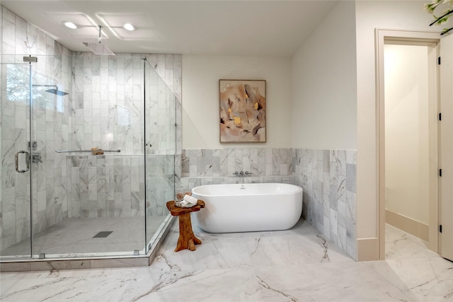 1322 Candlelight Ln, Houston, TX 77018 - bathroom featuring a soaking tub, marble finish floors, a shower stall, tile walls, and a wainscoted wall