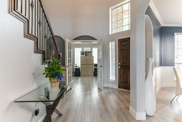 1753 Cranston Grove Dr, Dickinson, TX 77539 - foyer featuring arched walkways, wood finished floors, baseboards, stairway, and ornamental molding