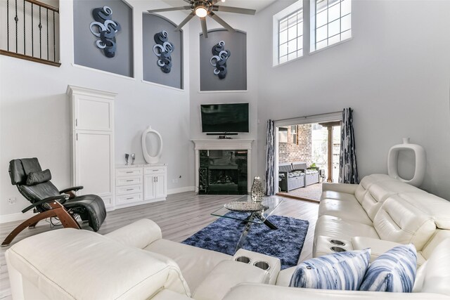 1753 Cranston Grove Dr, Dickinson, TX 77539 - living area with a towering ceiling, ceiling fan, a high end fireplace, baseboards, and light wood-type flooring