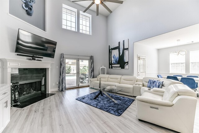 1753 Cranston Grove Dr, Dickinson, TX 77539 - living room featuring a ceiling fan, a towering ceiling, light wood finished floors, and a tile fireplace