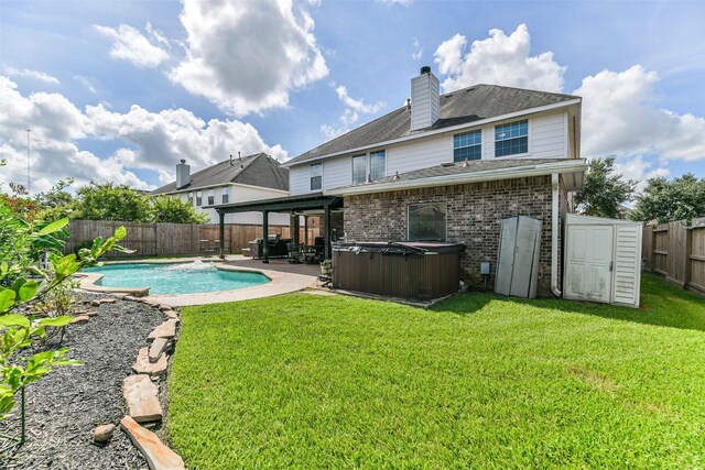1753 Cranston Grove Dr, Dickinson, TX 77539 - back of property featuring a hot tub, a patio area, brick siding, a chimney, and a shingled roof