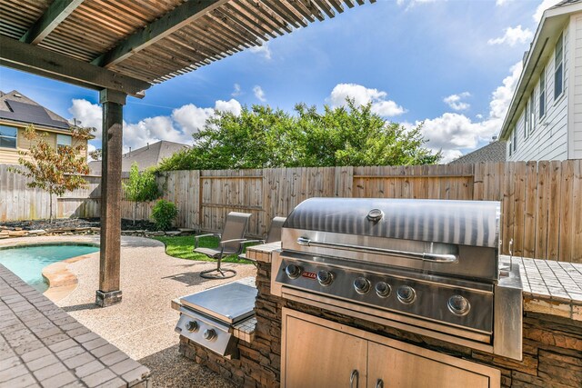 1753 Cranston Grove Dr, Dickinson, TX 77539 - view of patio featuring area for grilling, a fenced backyard, and an outdoor kitchen