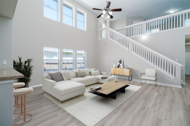213 Splintered Arrow Dr, La Marque, TX 77568 - living room with stairs, a high ceiling, ceiling fan, wood finished floors, and baseboards