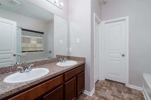 213 Splintered Arrow Dr, La Marque, TX 77568 - full bathroom featuring stone finish flooring, a tub to relax in, baseboards, and double vanity