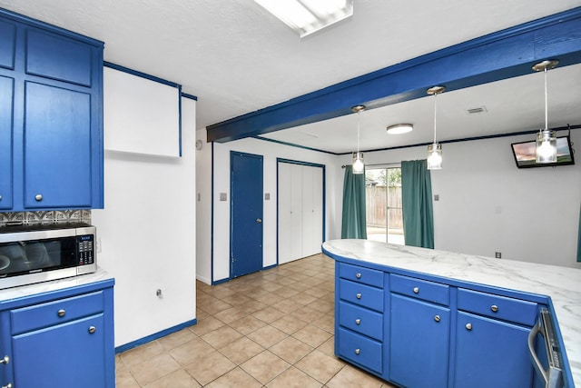 1207 Martingale Ct, Crosby, TX 77532 - kitchen with stainless steel microwave, light countertops, decorative light fixtures, and blue cabinets