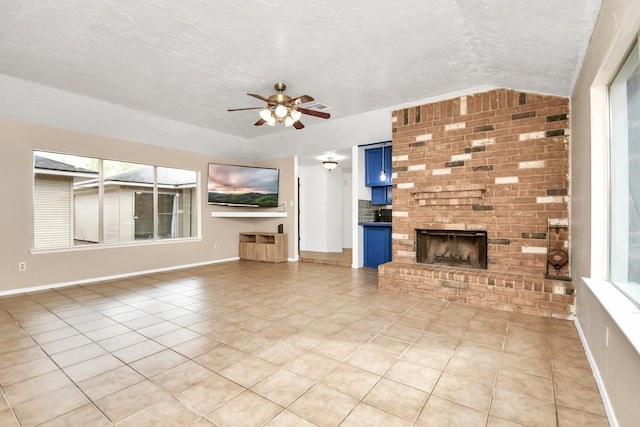 1207 Martingale Ct, Crosby, TX 77532 - unfurnished living room featuring light tile patterned flooring, ceiling fan, a textured ceiling, plenty of natural light, and a fireplace