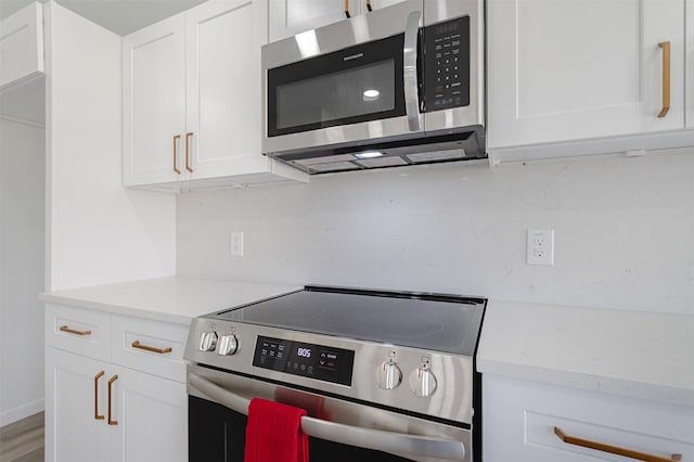 21511 Pepperberry Trl, Spring, TX 77388 - kitchen with appliances with stainless steel finishes, light countertops, white cabinetry, and wood finished floors