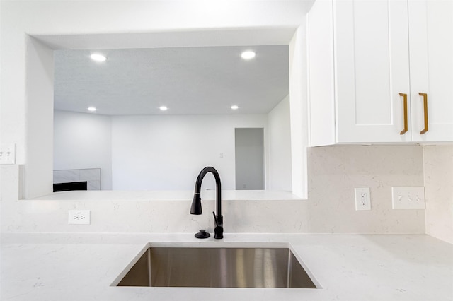 21511 Pepperberry Trl, Spring, TX 77388 - kitchen with a sink, light stone counters, white cabinets, recessed lighting, and tasteful backsplash