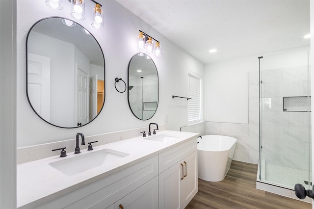 21511 Pepperberry Trl, Spring, TX 77388 - bathroom with a tile shower, wood finished floors, a freestanding bath, double vanity, and recessed lighting