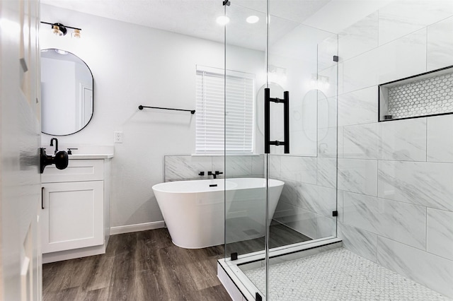 21511 Pepperberry Trl, Spring, TX 77388 - full bath with wood finished floors, a soaking tub, a stall shower, and vanity