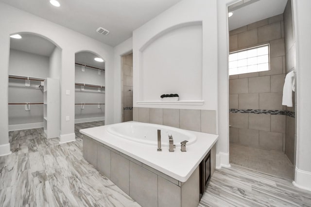 2948 S Cotswold Manor Dr, Kingwood, TX 77339 - bathroom with a walk in shower, a jetted tub, a spacious closet, recessed lighting, and baseboards