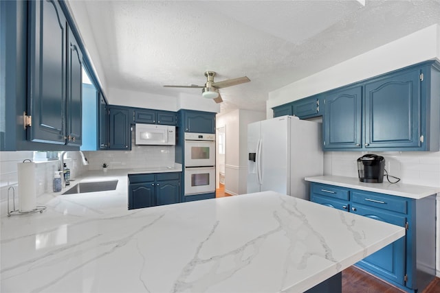 8223 Bairnsdale Ln, Houston, TX 77070 - kitchen featuring white appliances, a sink, a textured ceiling, a peninsula, and tasteful backsplash