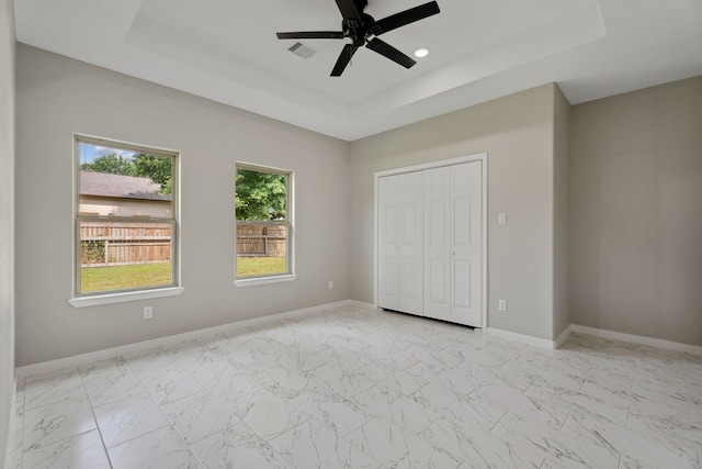 69 County Road 3668, Splendora, TX 77372 - unfurnished bedroom featuring a tray ceiling, light marble finish floors, baseboards, and recessed lighting