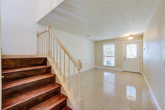 2815 Lakefield Way, Sugar Land, TX 77479 - foyer featuring a textured ceiling, light tile patterned floors, stairs, and baseboards