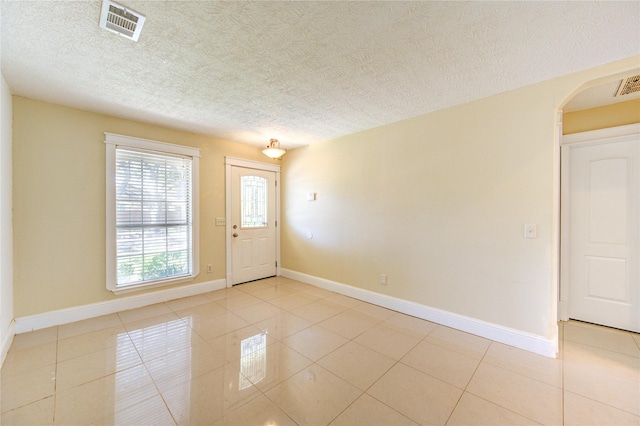 2815 Lakefield Way, Sugar Land, TX 77479 - entrance foyer featuring baseboards, light tile patterned floors, arched walkways, and a textured ceiling