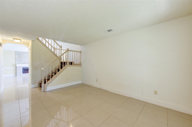 2815 Lakefield Way, Sugar Land, TX 77479 - empty room featuring stairs, baseboards, light tile patterned flooring, and a textured ceiling
