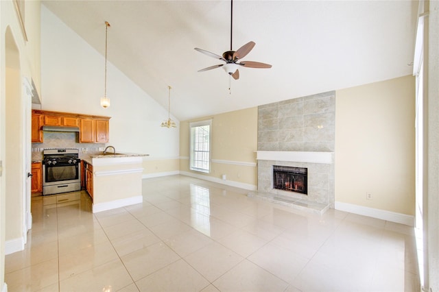 2815 Lakefield Way, Sugar Land, TX 77479 - unfurnished living room featuring a ceiling fan, a sink, a fireplace, baseboards, and high vaulted ceiling