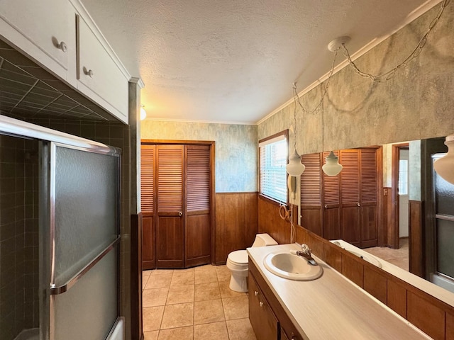 121 Briar Ln, Crockett, TX 75835 - full bathroom featuring a shower stall, toilet, vanity, tile patterned floors, and a wainscoted wall