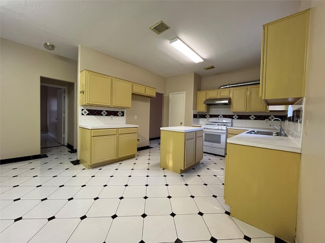 11830 Meadow Place Dr, Houston, TX 77071 - kitchen featuring white range with gas stovetop, a sink, under cabinet range hood, tasteful backsplash, and light flooring
