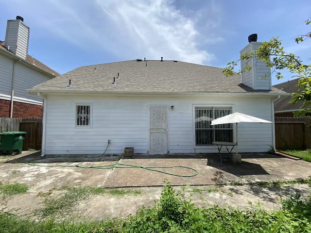 11830 Meadow Place Dr, Houston, TX 77071 - back of property with fence, a patio area, a shingled roof, and a chimney