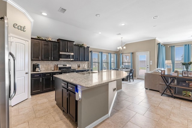 20735 Cactus Lake Ln, Richmond, TX 77407 - kitchen with stainless steel appliances, a sink, decorative backsplash, a chandelier, and light stone countertops