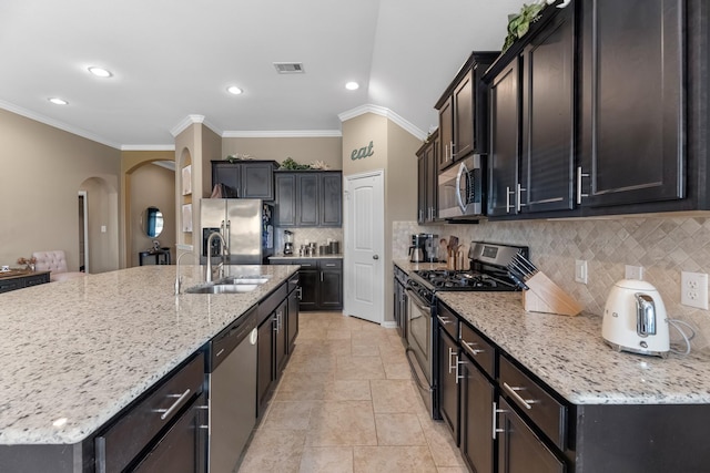 20735 Cactus Lake Ln, Richmond, TX 77407 - kitchen with appliances with stainless steel finishes, arched walkways, a sink, decorative backsplash, and ornamental molding