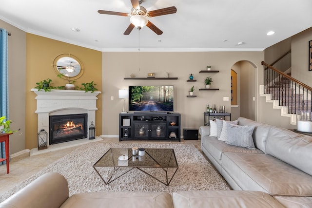 20735 Cactus Lake Ln, Richmond, TX 77407 - tiled living room with ceiling fan, arched walkways, crown molding, stairway, and a glass covered fireplace