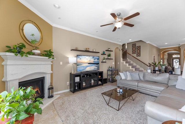 20735 Cactus Lake Ln, Richmond, TX 77407 - tiled living room featuring arched walkways, ceiling fan, stairway, crown molding, and a glass covered fireplace
