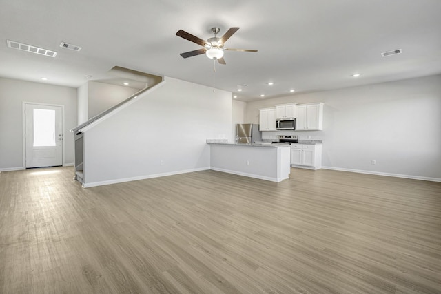 6405 Winter Elm St, Houston, TX 77048 - unfurnished living room with baseboards, a ceiling fan, light wood-style floors, recessed lighting, and stairs