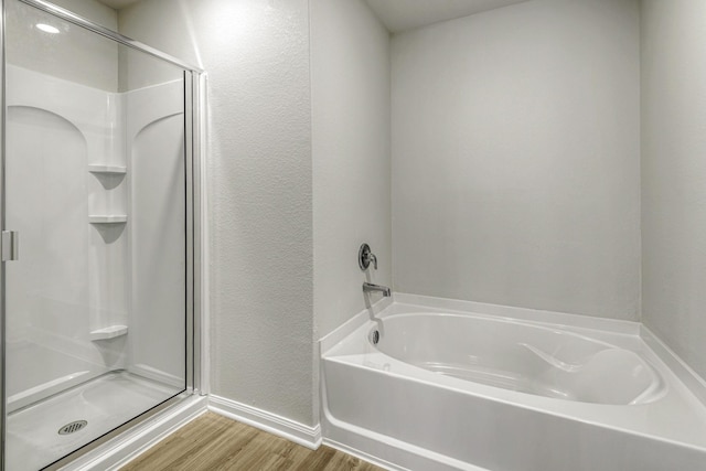 6405 Winter Elm St, Houston, TX 77048 - bathroom featuring wood finished floors, a shower stall, a garden tub, baseboards, and a textured wall