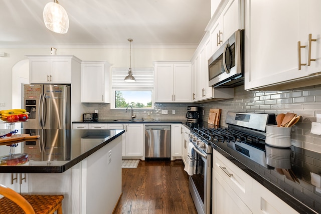 829 Wakefield Dr Unit A, Houston, TX 77018 - kitchen featuring appliances with stainless steel finishes, dark countertops, a kitchen breakfast bar, a sink, and decorative backsplash