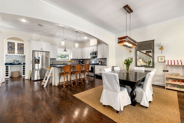 829 Wakefield Dr Unit A, Houston, TX 77018 - dining room featuring ornamental molding, dark wood finished floors, arched walkways, and recessed lighting