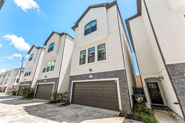 829 Wakefield Dr Unit A, Houston, TX 77018 - townhome / multi-family property featuring stone siding, a garage, driveway, and stucco siding