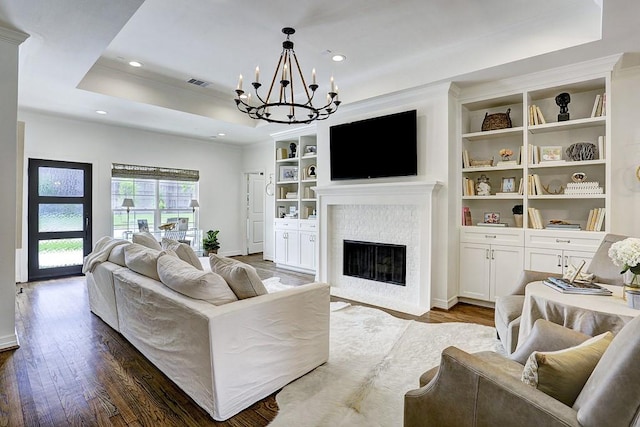 5326 Windswept Ln, Houston, TX 77056 - living room featuring a tray ceiling, dark wood-style flooring, a chandelier, a fireplace with flush hearth, and ornamental molding