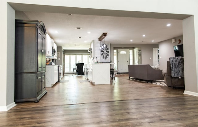 14902 Bernard Timbers Dr, East Bernard, TX 77435 - kitchen with open floor plan, dark wood-style floors, recessed lighting, stainless steel microwave, and baseboards