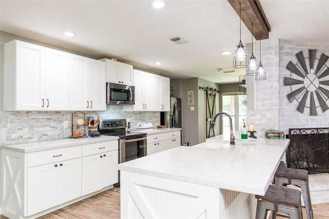 14902 Bernard Timbers Dr, East Bernard, TX 77435 - kitchen featuring stainless steel appliances, a sink, a kitchen bar, a peninsula, and backsplash