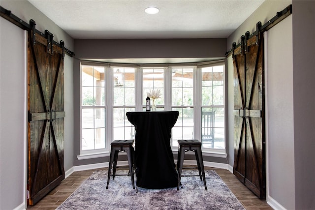 14902 Bernard Timbers Dr, East Bernard, TX 77435 - dining area featuring a barn door, baseboards, and dark wood-style floors