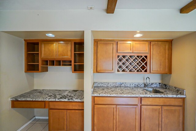 18907 Oak Bower Dr, Humble, TX 77346 - kitchen with a sink, light stone counters, light tile patterned floors, beamed ceiling, and open shelves