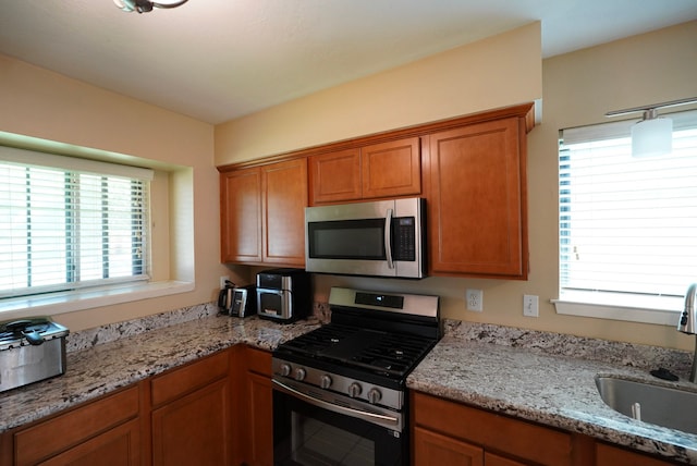 18907 Oak Bower Dr, Humble, TX 77346 - kitchen with appliances with stainless steel finishes, a sink, healthy amount of natural light, and brown cabinets