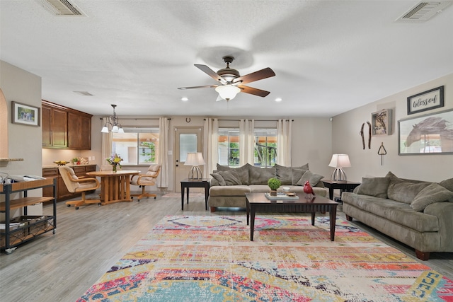 13111 Oak Plaza Dr, Cypress, TX 77429 - living room with plenty of natural light, a ceiling fan, light wood-style floors, recessed lighting, and a chandelier