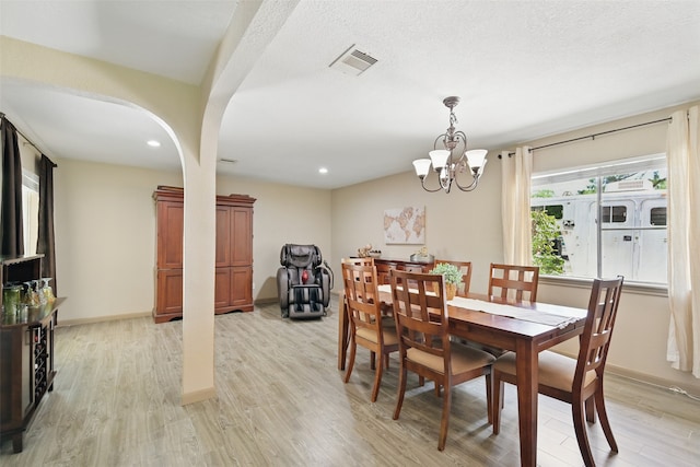 13111 Oak Plaza Dr, Cypress, TX 77429 - dining space with light wood-style floors, arched walkways, a chandelier, recessed lighting, and baseboards