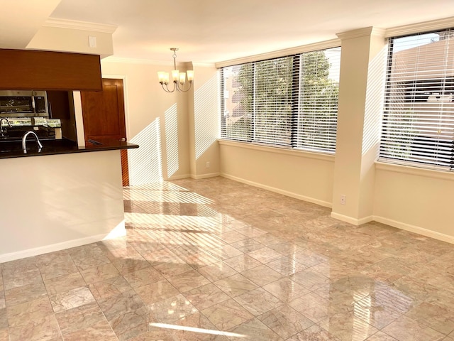 3525 Sage Rd Unit 404, Houston, TX 77056 - kitchen featuring ornamental molding, stainless steel microwave, a chandelier, baseboards, and dark countertops