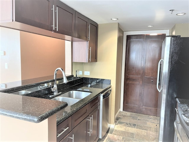 3525 Sage Rd Unit 404, Houston, TX 77056 - kitchen featuring stainless steel appliances, dark stone counters, dark brown cabinets, a sink, and recessed lighting