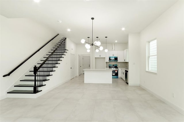 4008 Bennington St, Houston, TX 77016 - kitchen featuring stainless steel microwave, gas range oven, a chandelier, baseboards, and a center island