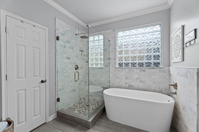 16810 Tranquility Park Dr, Cypress, TX 77429 - bathroom featuring a soaking tub, a shower stall, tile walls, and ornamental molding