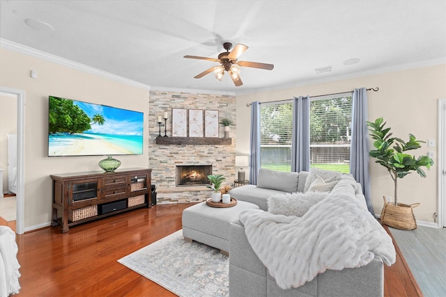 16810 Tranquility Park Dr, Cypress, TX 77429 - living room featuring crown molding, ceiling fan, wood finished floors, a stone fireplace, and baseboards