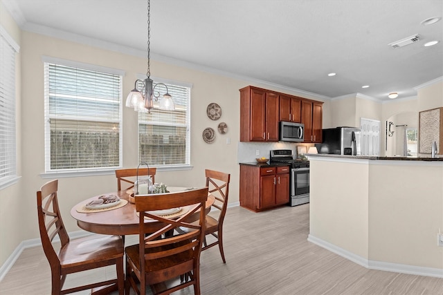16810 Tranquility Park Dr, Cypress, TX 77429 - kitchen with stainless steel appliances, a chandelier, light wood-style floors, crown molding, and recessed lighting