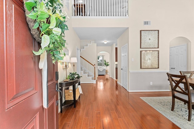 16810 Tranquility Park Dr, Cypress, TX 77429 - foyer entrance featuring arched walkways, stairway, wood finished floors, baseboards, and a high ceiling