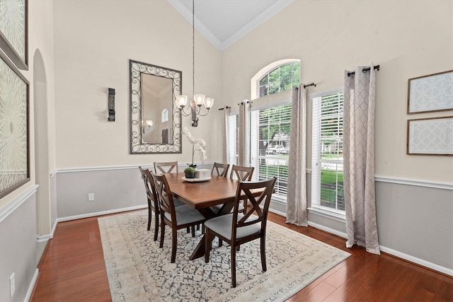 16810 Tranquility Park Dr, Cypress, TX 77429 - dining area featuring ornamental molding, a chandelier, dark wood-style flooring, baseboards, and high vaulted ceiling